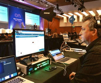 AV technician sitting behind computer display at technology conference in San Francisco.