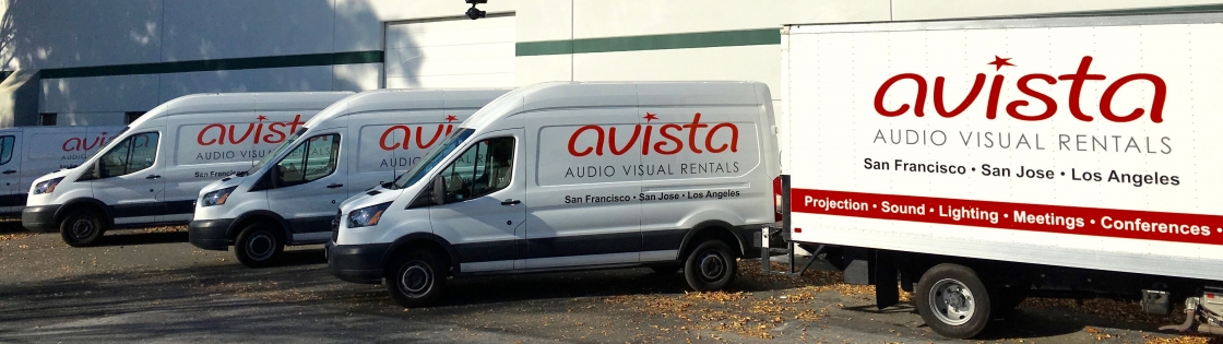 Row of Avista AV Rentals vans and truck in parking lot.