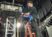 AV technician on ladder setting up projector in san jose