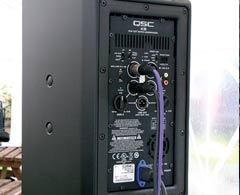Back panel of black QSC K8 speaker.