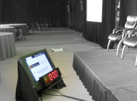Close up of conference monitor set up next to indoor conference stage