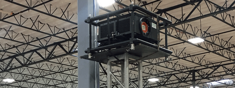 A large Christie projector mounted atop a piece of truss